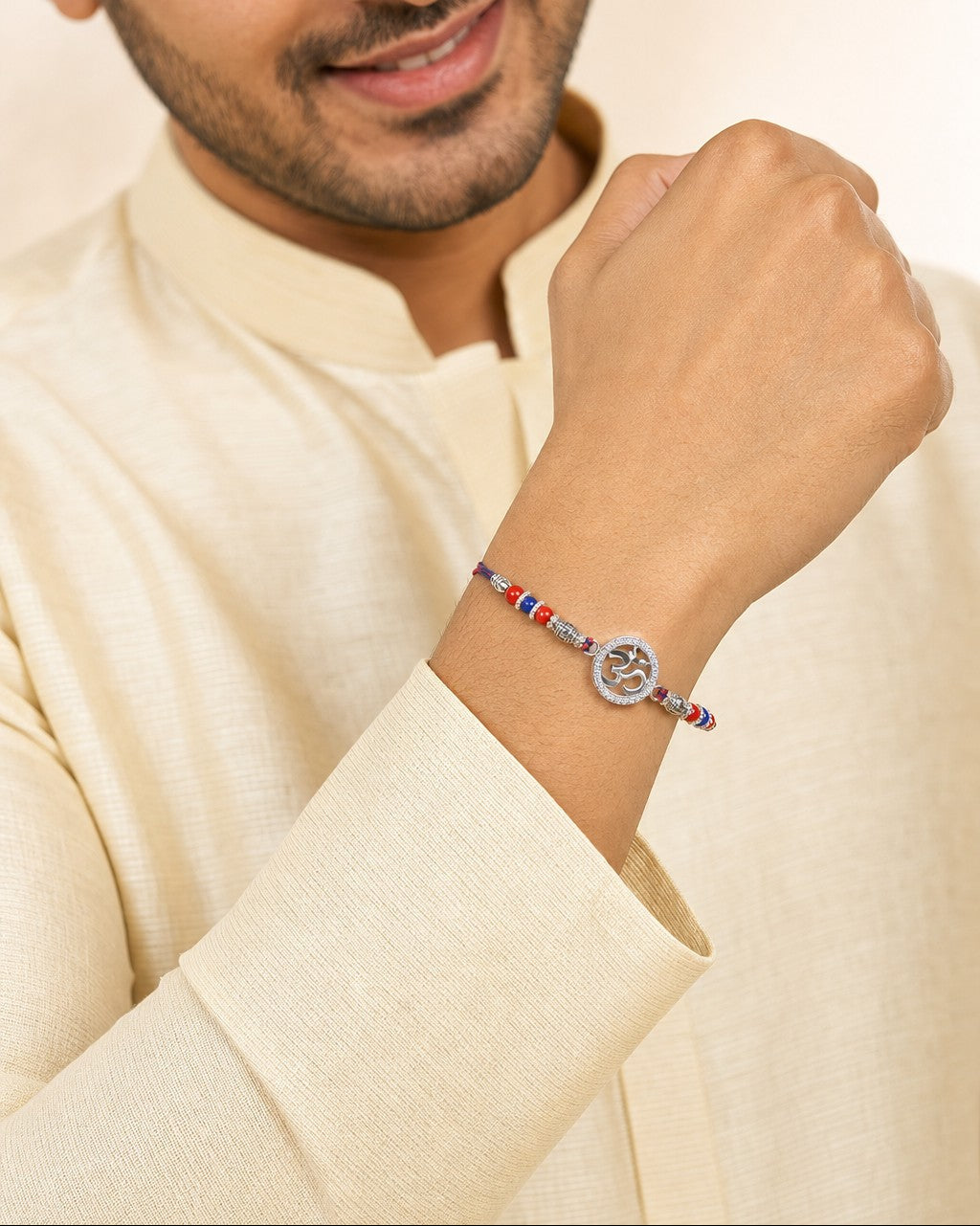 A man wearing the silver Om Rakhi bracelet with CZ halo on his wrist