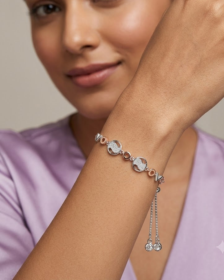 Woman wearing a silver bracelet with heart charms on a neutral background