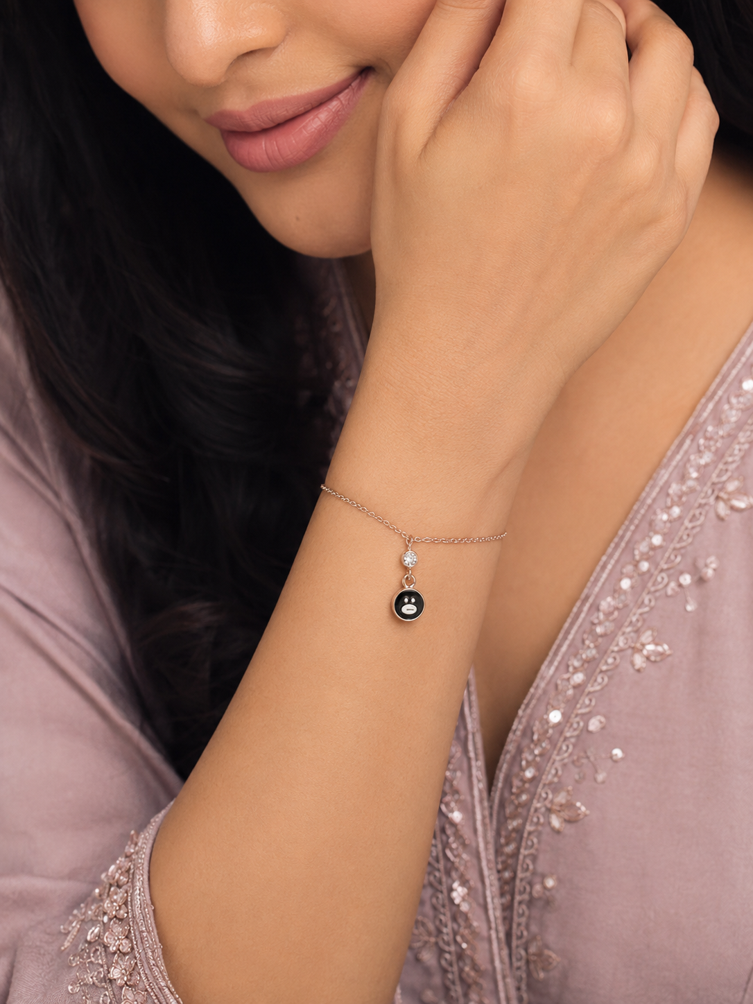 Woman wearing a delicate necklace with a small pendant, close-up of the necklace.