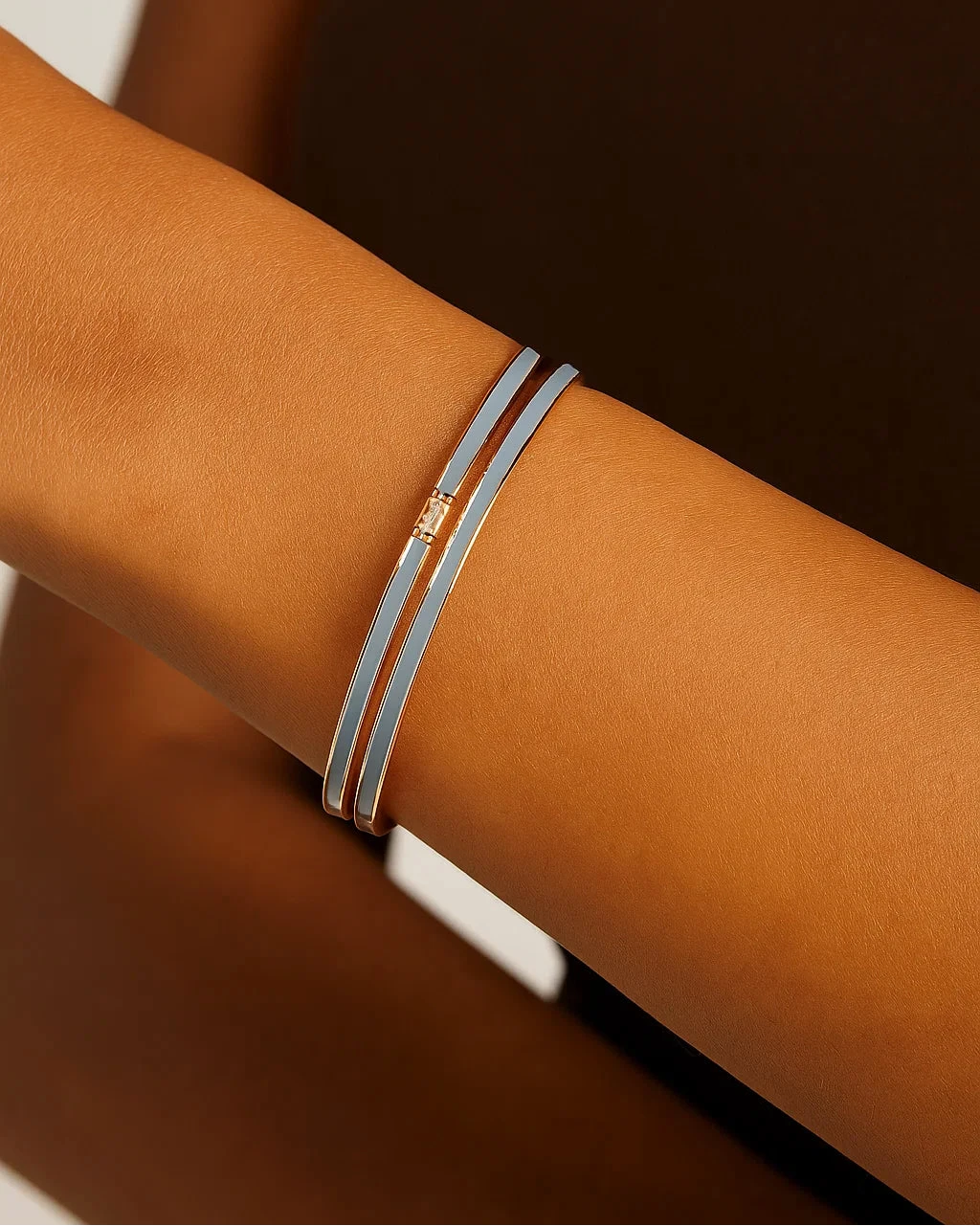 Close-up of a wrist wearing a silver bracelet with a gold clasp