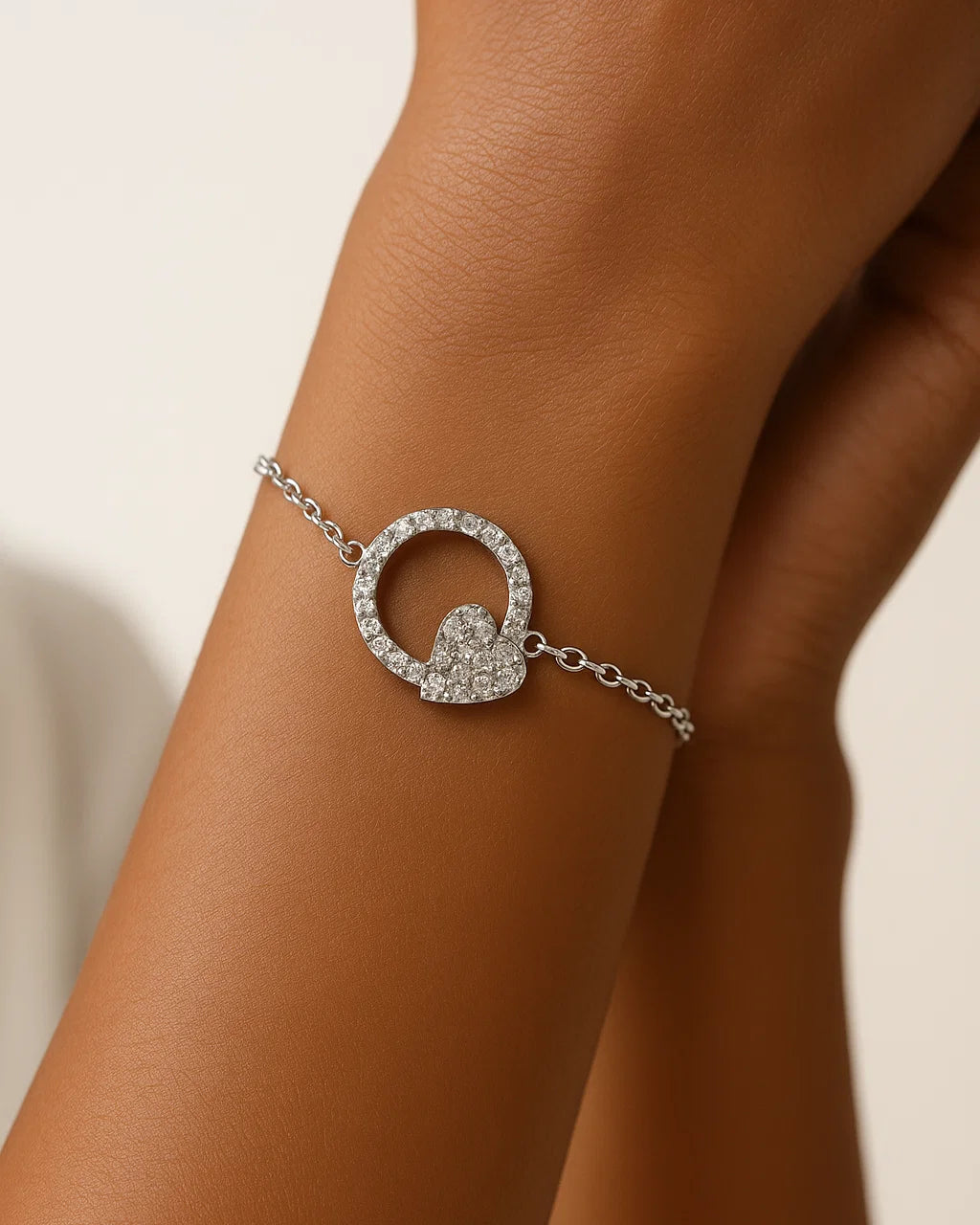 Silver bracelet with a circular design on a wrist against a neutral background