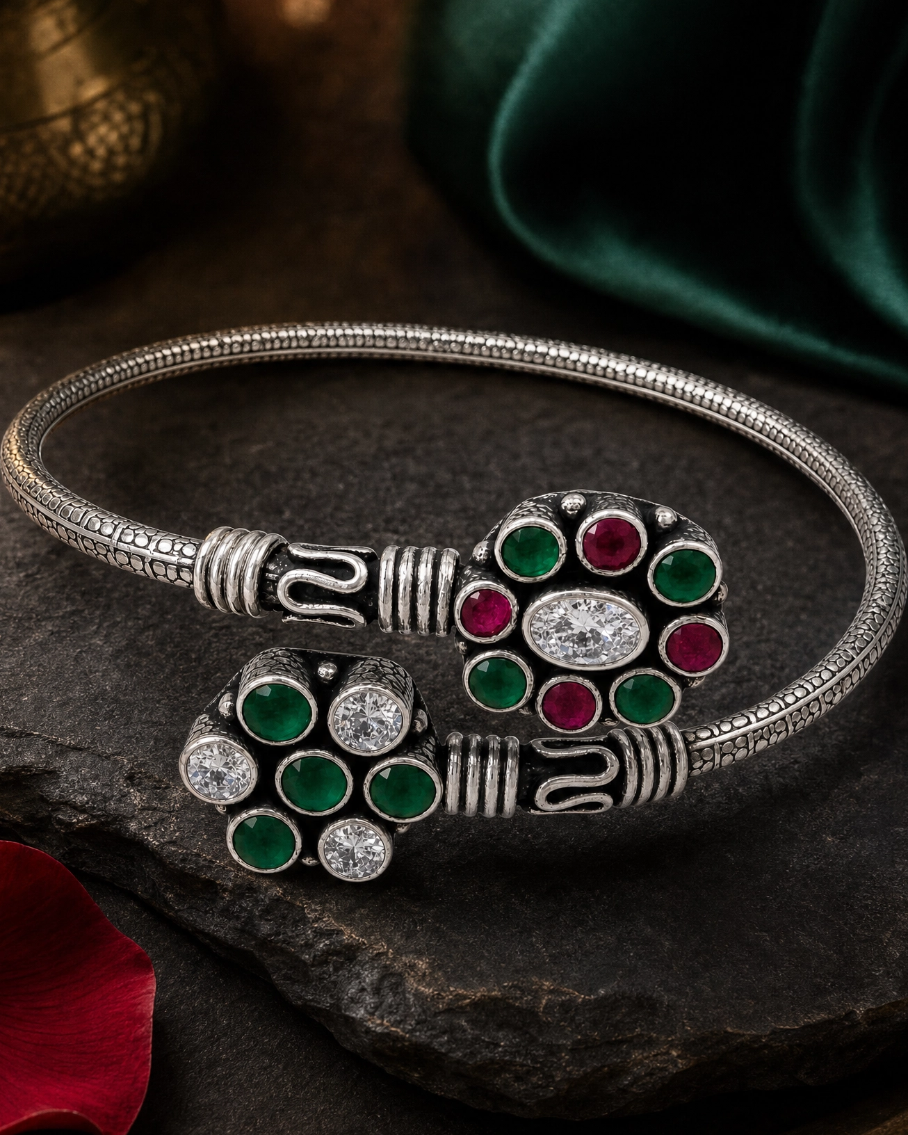Silver bracelet with colorful gemstones on a dark stone surface