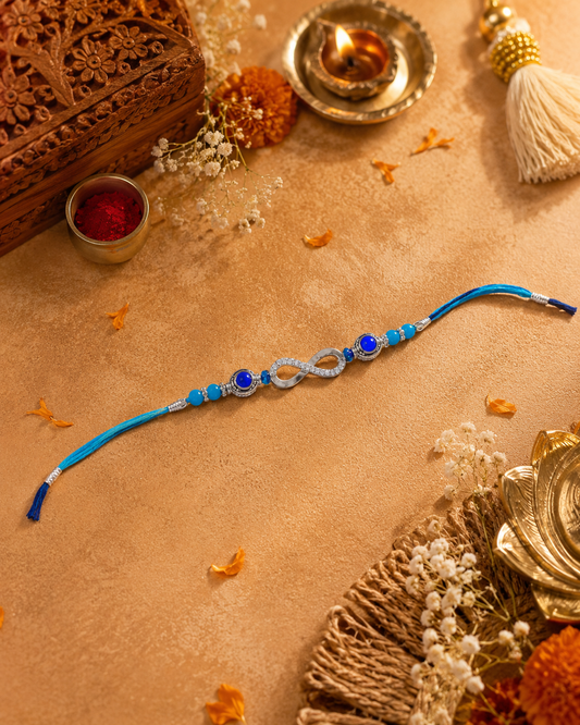 Decorative blue and silver rakhi on a brown surface with decorative elements