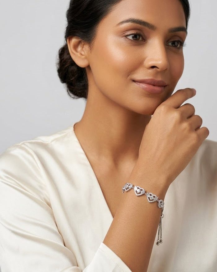 Woman wearing a silver bracelet with a plain background