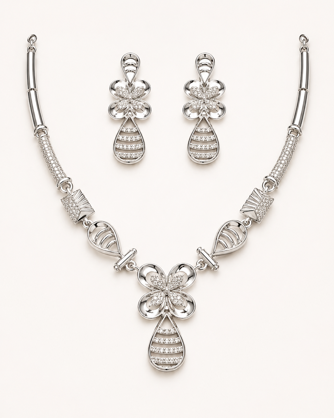 Silver necklace and earrings set on a white background