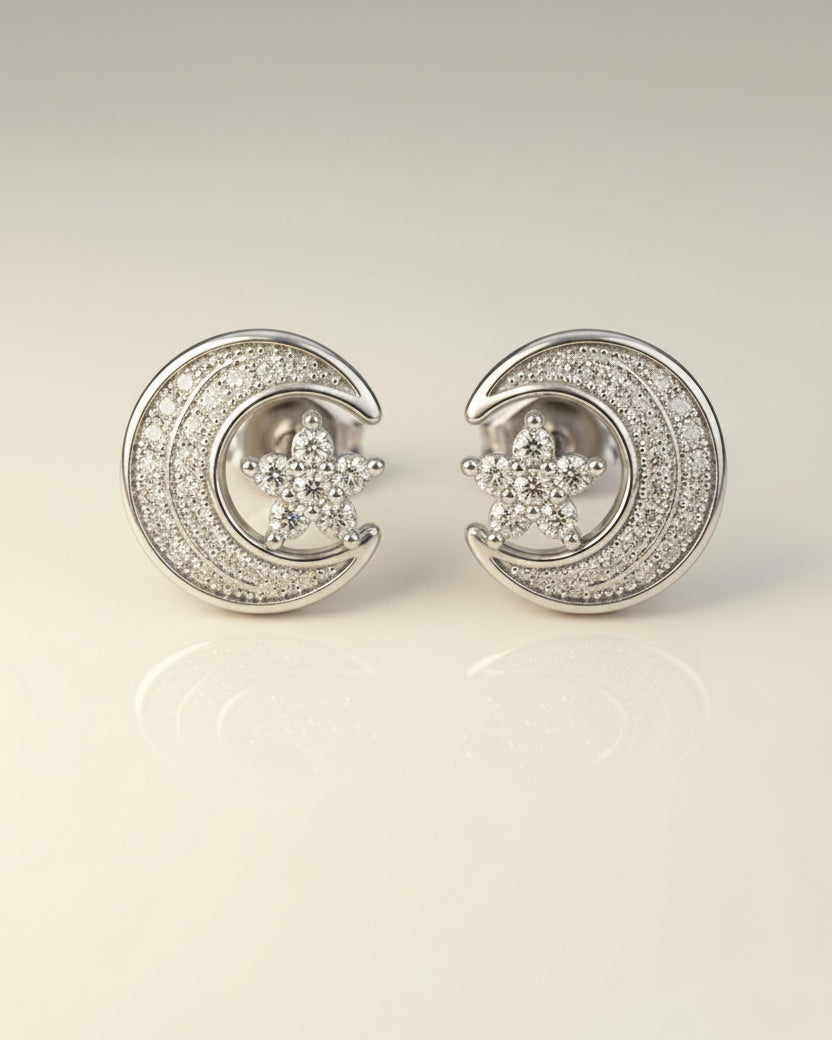 Silver moon and star earrings on a light gray background