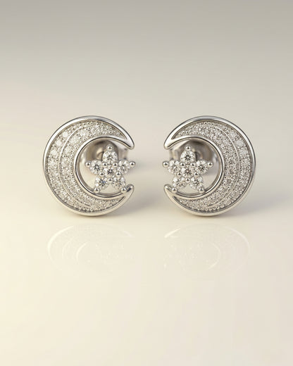 Silver moon and star earrings on a light gray background