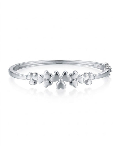 Silver bracelet with floral designs on a white background
