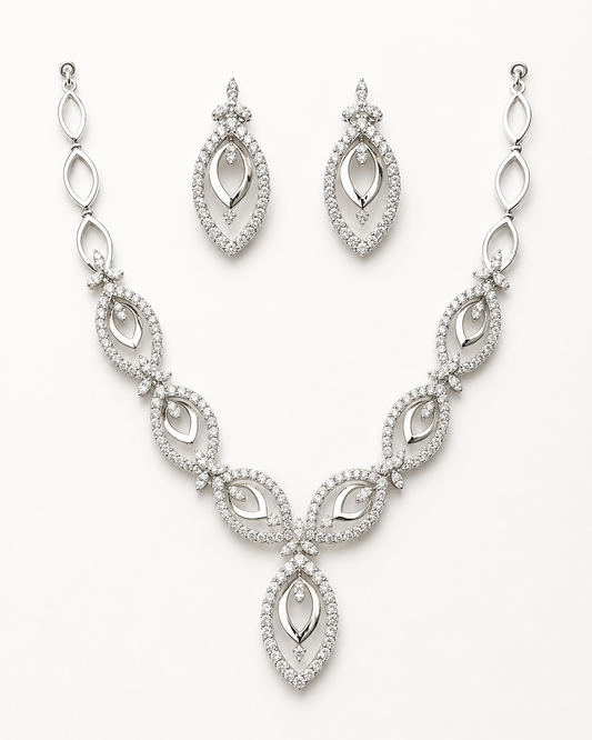 Silver necklace and earrings set on a white background