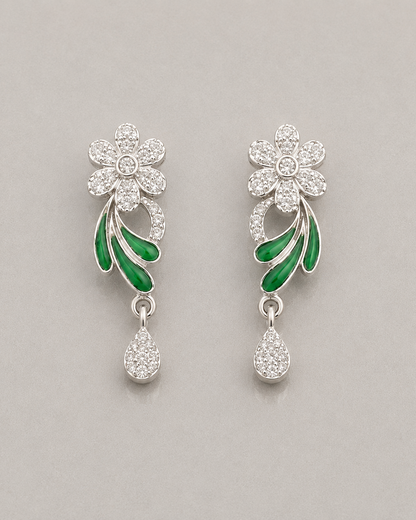 Floral earrings with green leaves and clear stones on a gray background