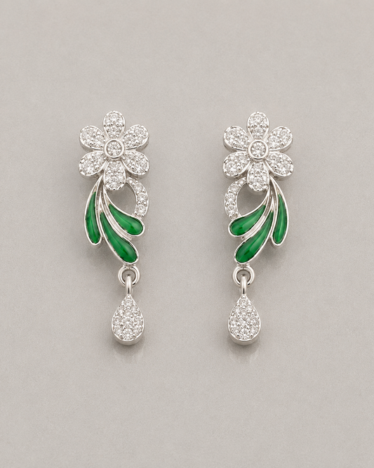 Floral earrings with green leaves and clear stones on a gray background