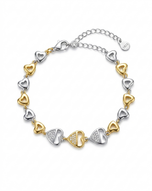 Bracelet with heart-shaped links in gold and silver on a white background