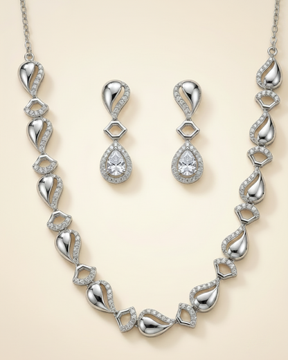 Silver necklace and earrings set on a beige background