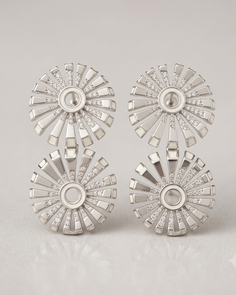 Set of silver earrings with starburst design on a light gray background