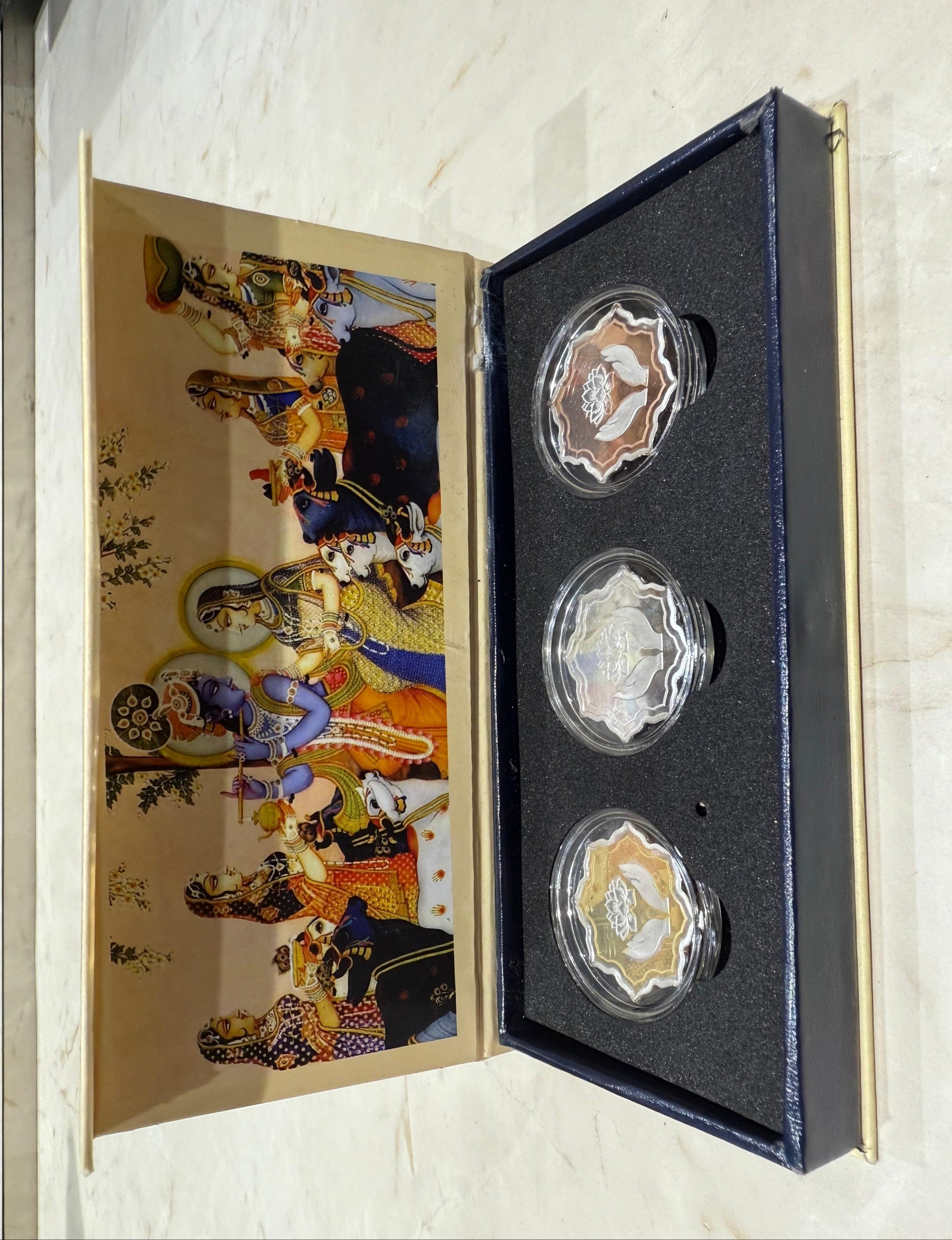 Set of three coins in a decorative box with artistic design