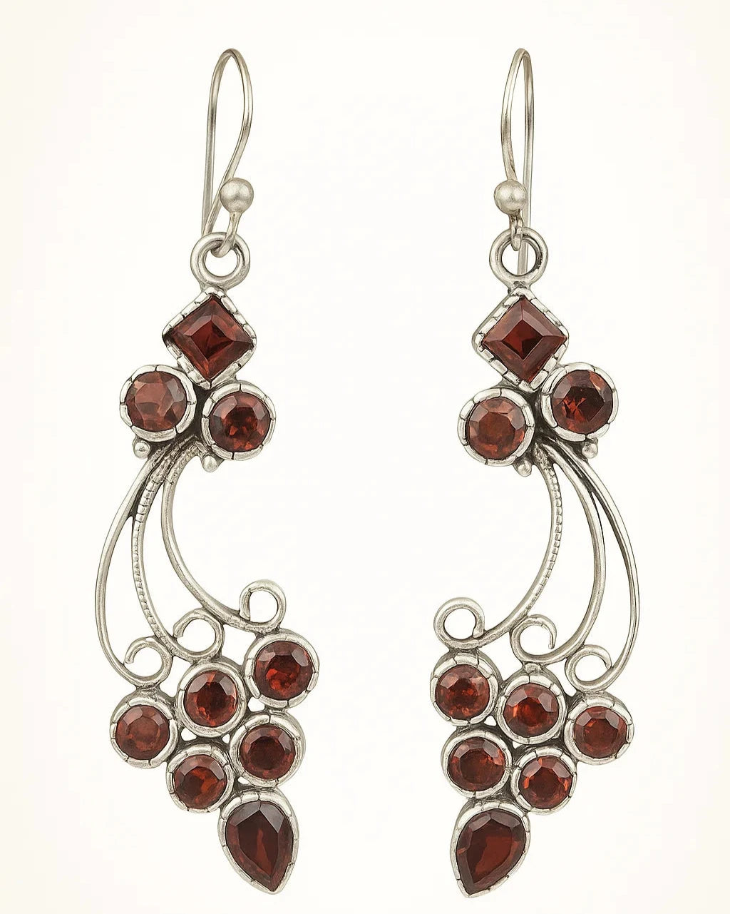 Pair of silver earrings with red gemstones on a white background