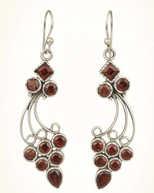 Pair of silver earrings with red gemstones on a white background