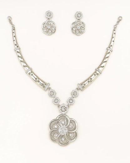 Silver necklace and earrings set on a white background
