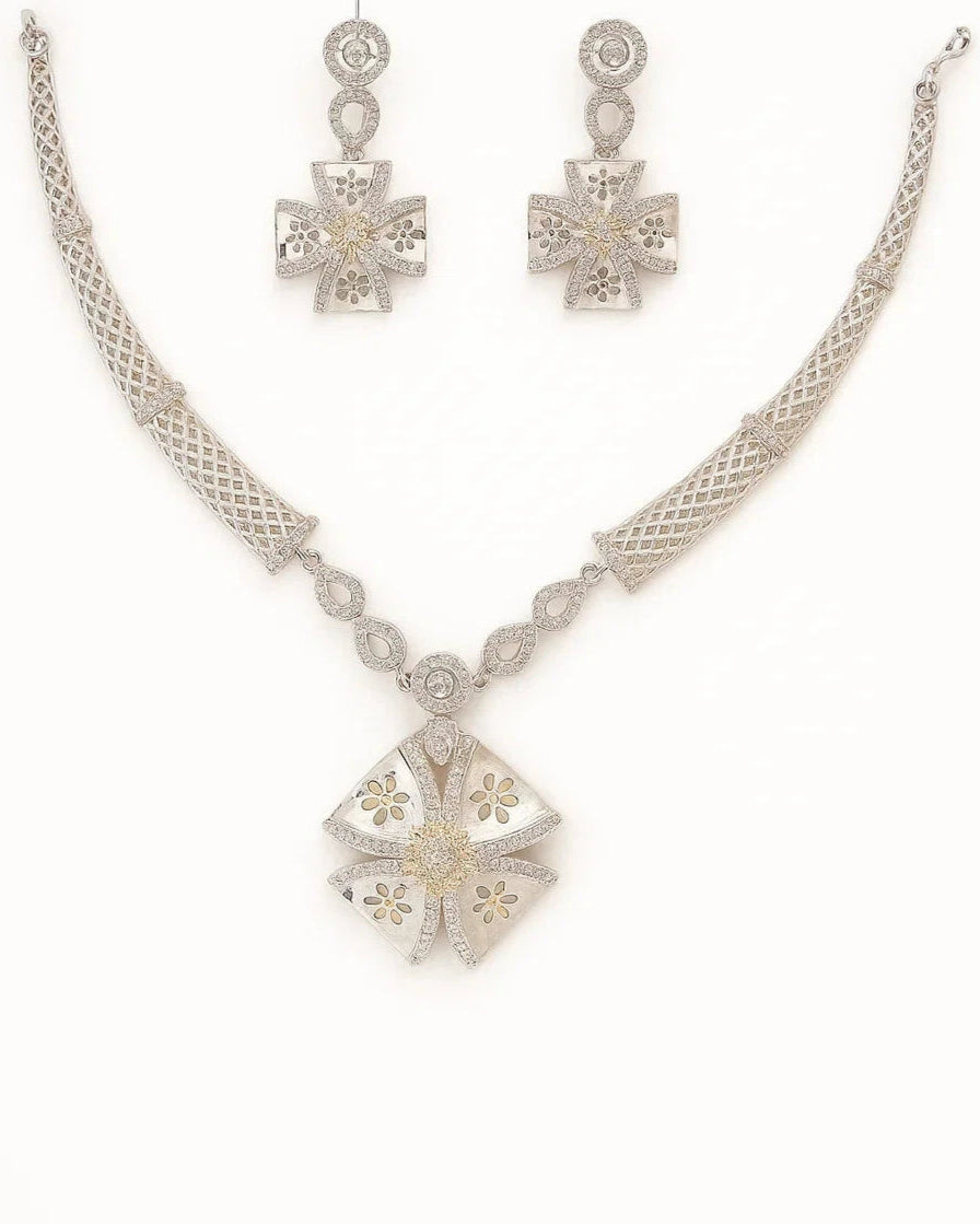 Silver necklace and earrings set on a white background