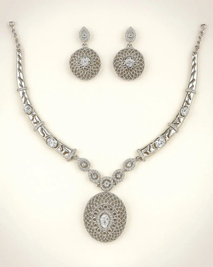 Silver necklace and earrings set on a light background