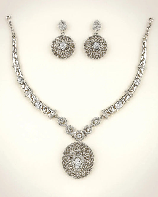 Silver necklace and earrings set on a light background