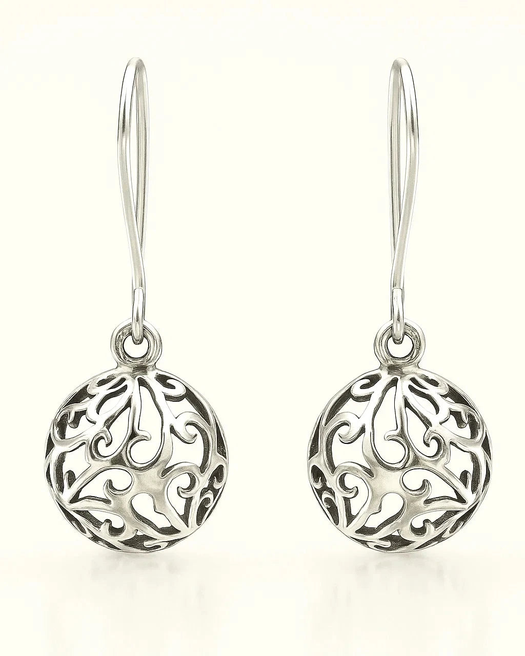 Pair of silver earrings with intricate designs on a white background