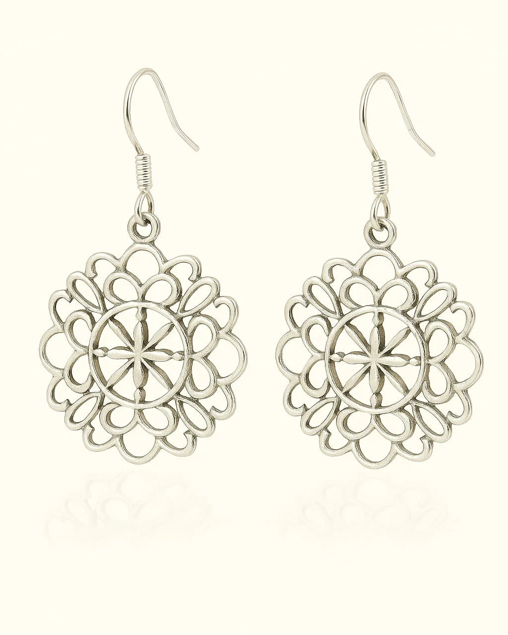 Pair of silver floral earrings on a white background