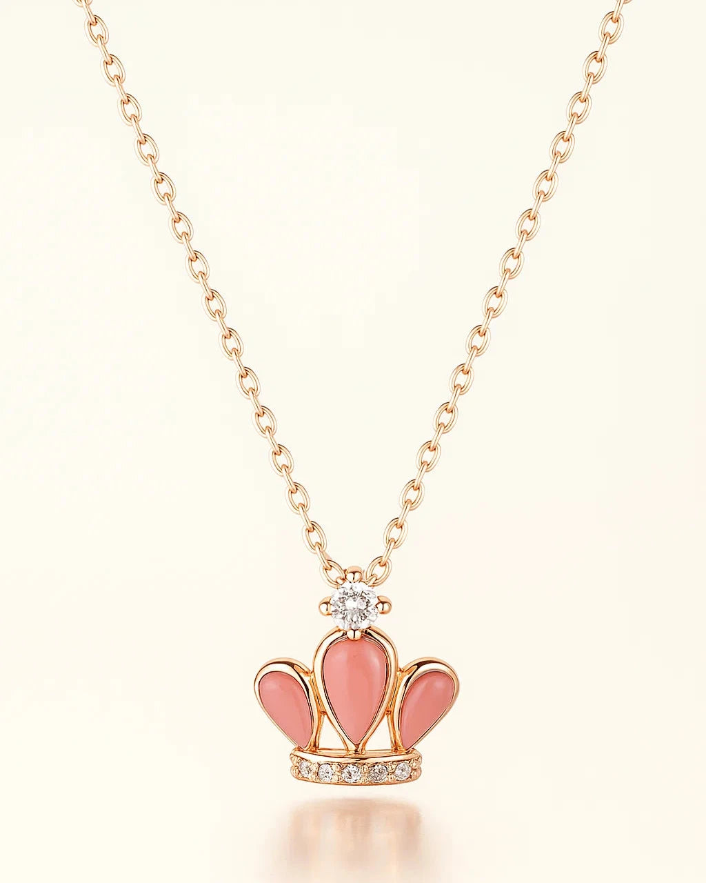 Necklace with a pink crown pendant on a light background