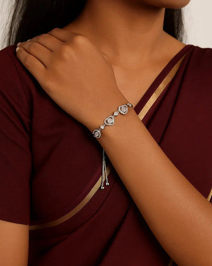 Person wearing a maroon saree with a silver bracelet