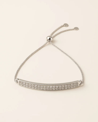 Silver bracelet with clear stones on a beige background