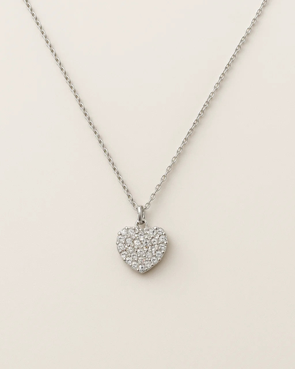 Heart-shaped pendant necklace on a light beige background