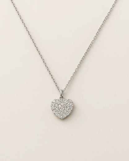 Heart-shaped pendant necklace on a light beige background