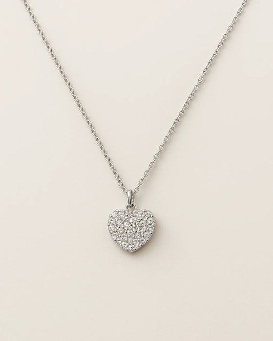 Heart-shaped pendant necklace on a light beige background