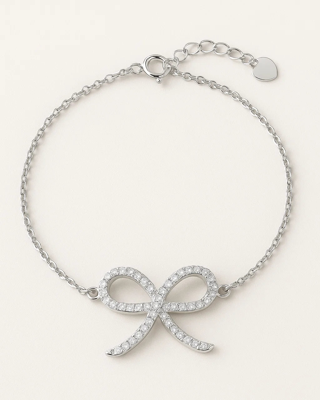 Silver bracelet with bow design on a white background