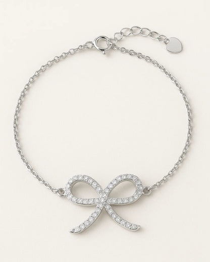 Silver bracelet with bow design on a white background
