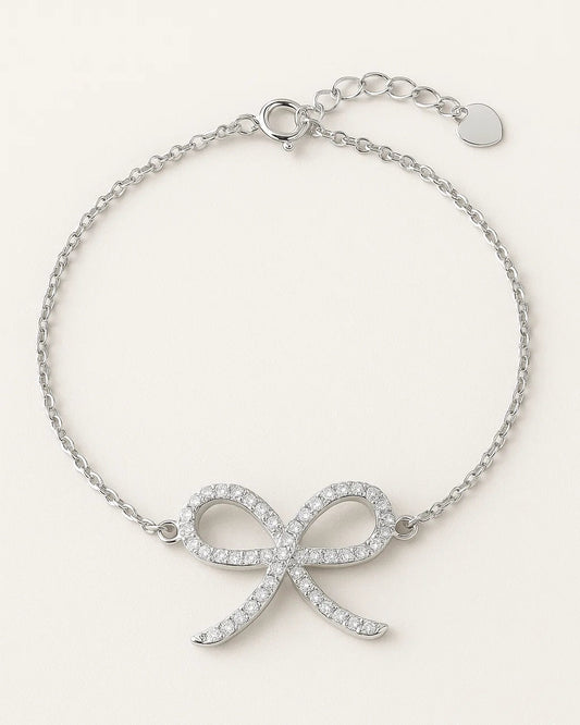 Silver bracelet with bow design on a white background