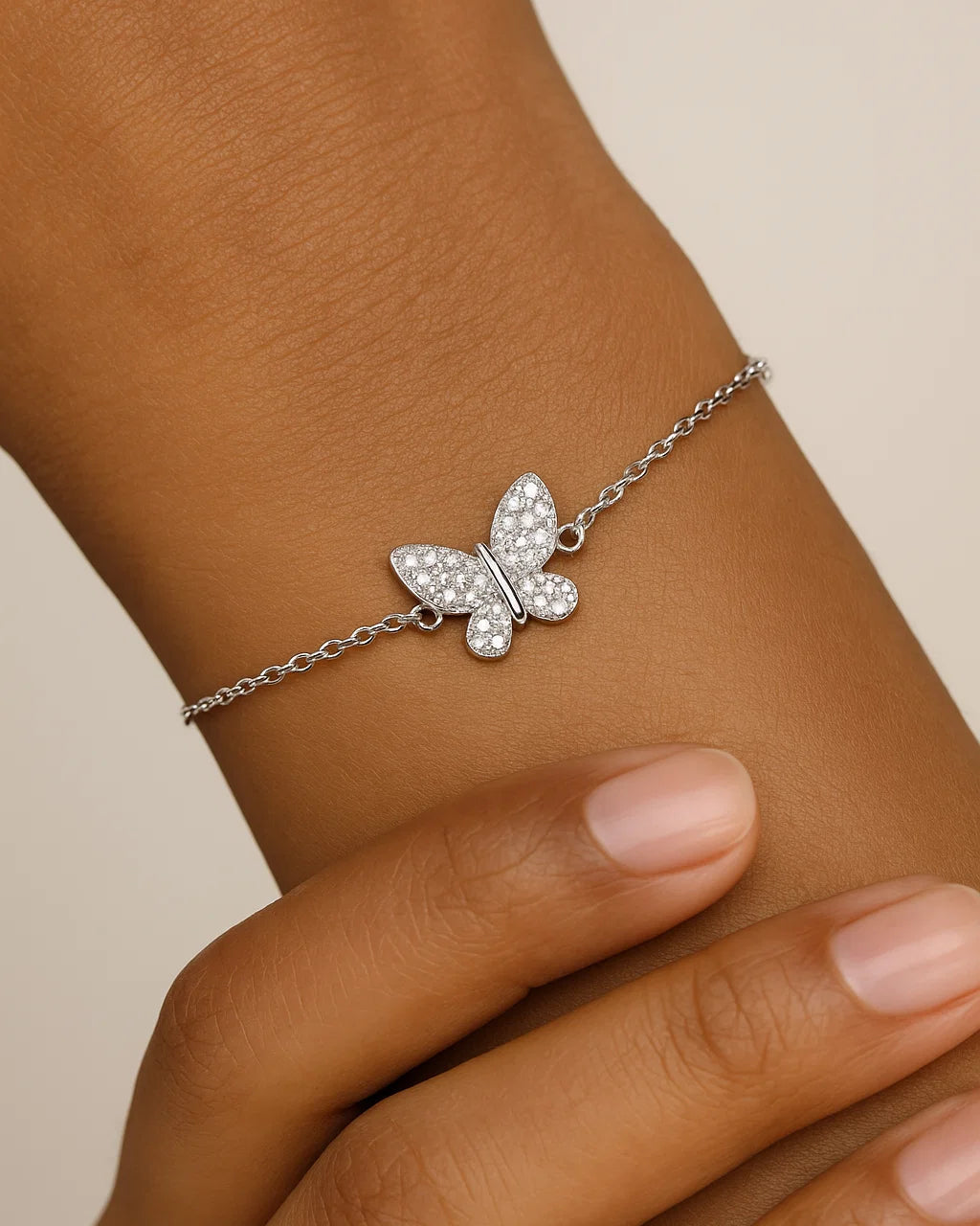Butterfly bracelet on a wrist with a neutral background