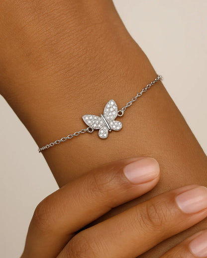 Butterfly bracelet on a wrist with a neutral background