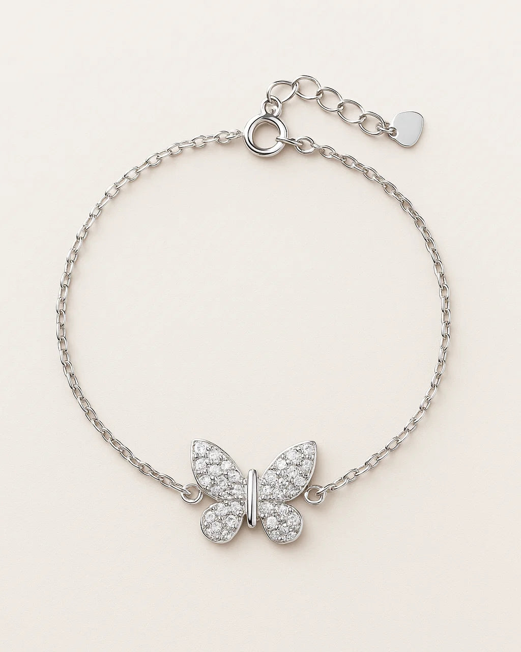 Silver butterfly bracelet with clear stones on a light beige background