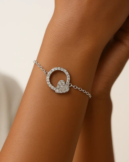 Silver bracelet with a circular design on a wrist against a neutral background