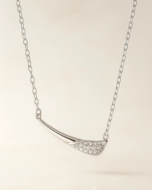 Silver necklace with a curved pendant on a light background