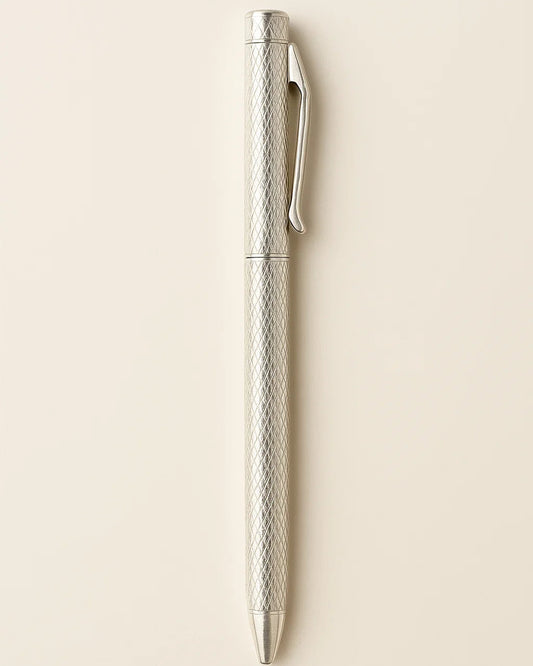 Silver pen with textured design on a beige background