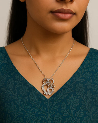 Woman wearing a silver necklace with an intricate pendant against a neutral background