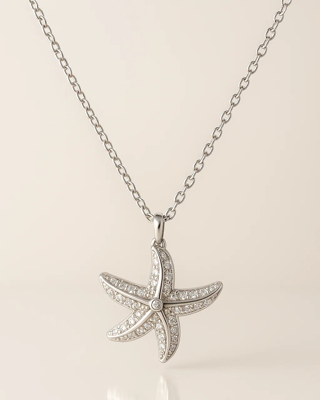 Starfish pendant necklace on a beige background