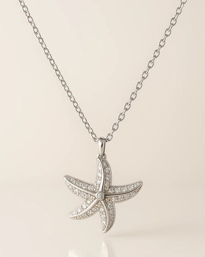 Starfish pendant necklace on a beige background