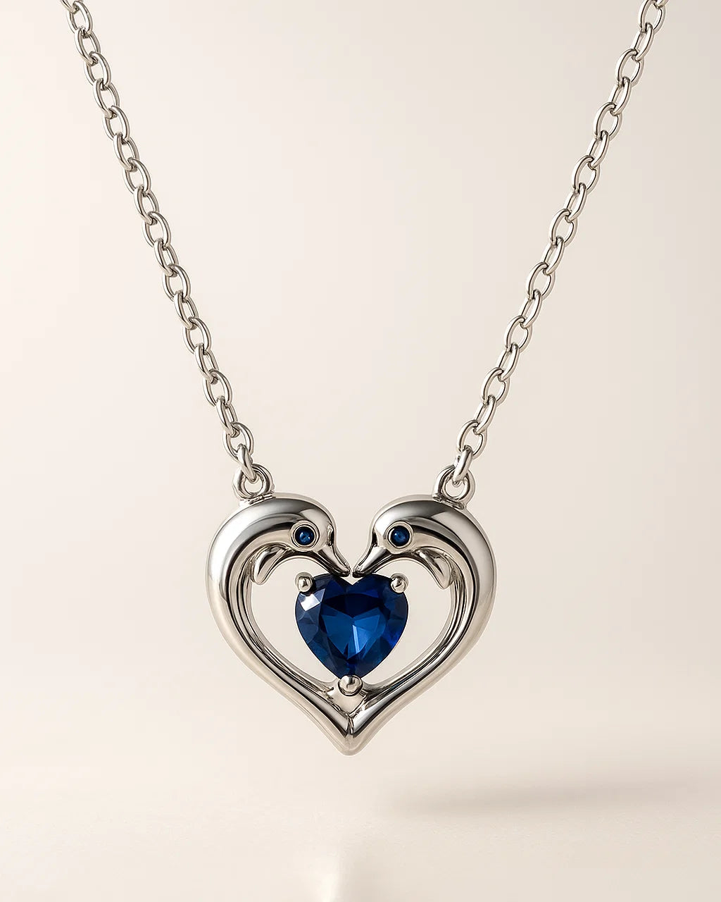 Heart-shaped necklace with a blue gemstone on a light background