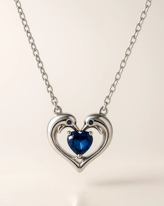 Heart-shaped necklace with a blue gemstone on a light background