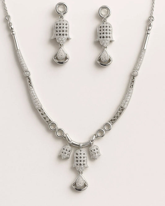 Silver necklace and earrings set on a white background