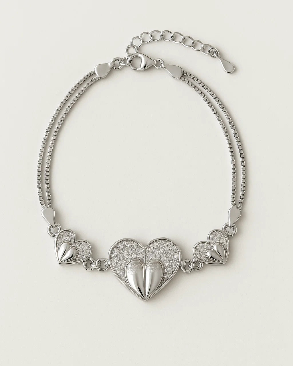 Silver bracelet with heart-shaped charms on a light beige background