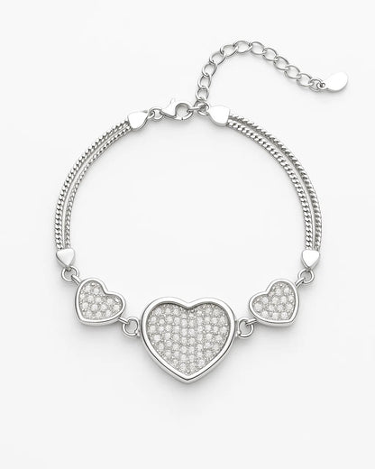 Silver bracelet with heart-shaped charms on a white background